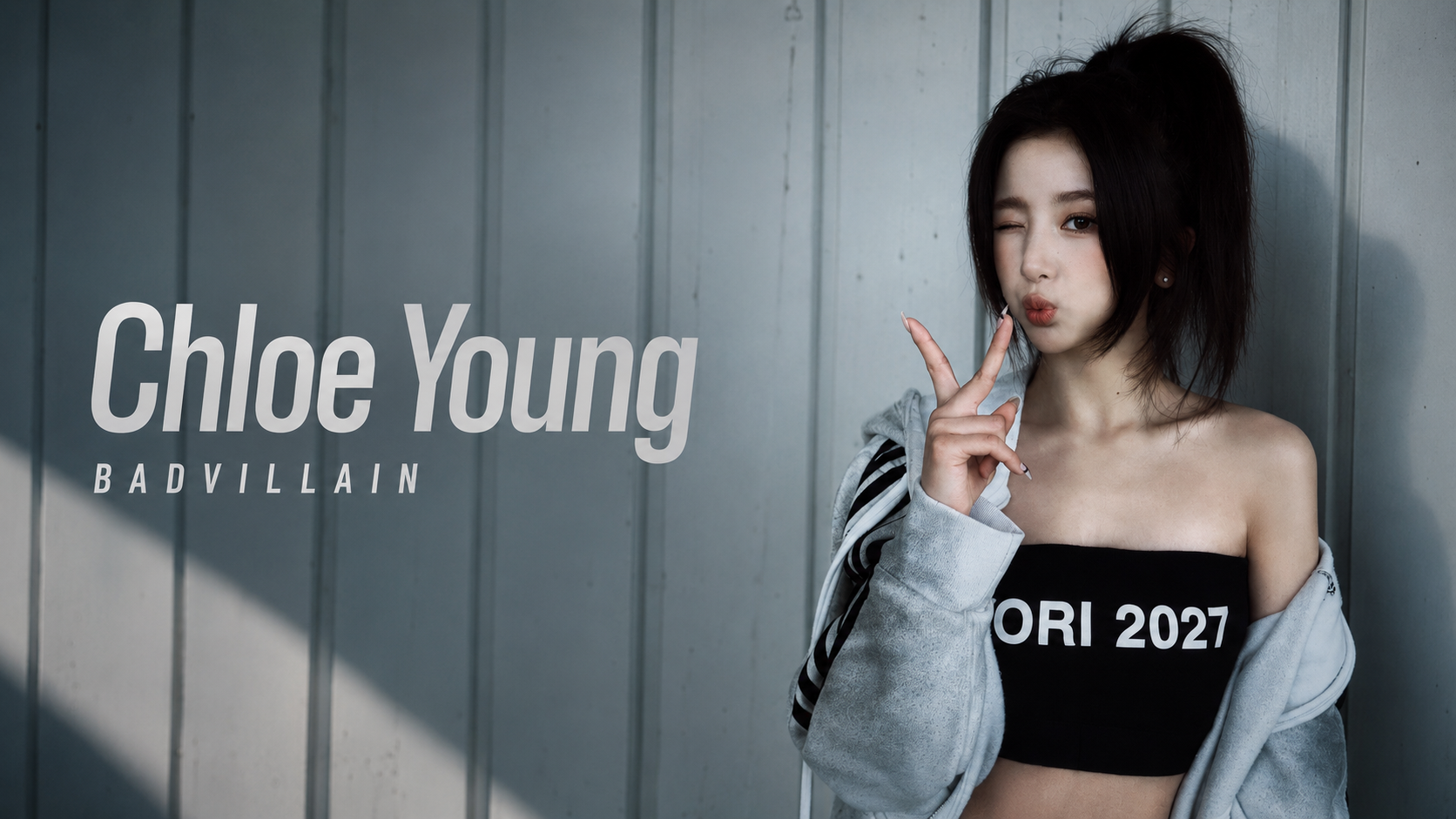 BADVILLAIN成員Chloe Young肖像，Chloe Young穿黑色上衣與灰色外套擺出手勢