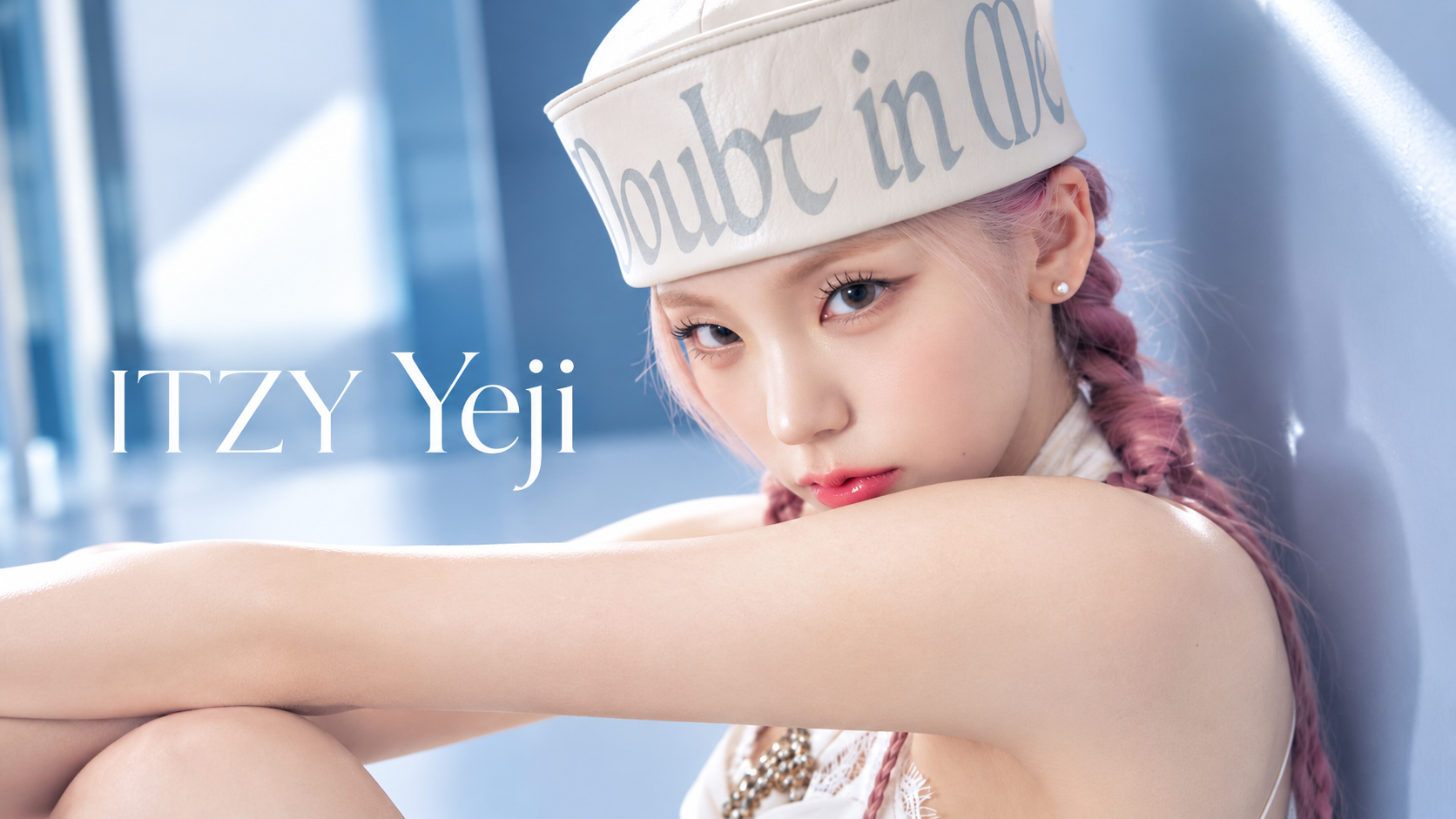ITZY Yeji 宣傳形象照,粉紅編髮女性戴白色帽子並穿白色服裝坐在藍色背景前