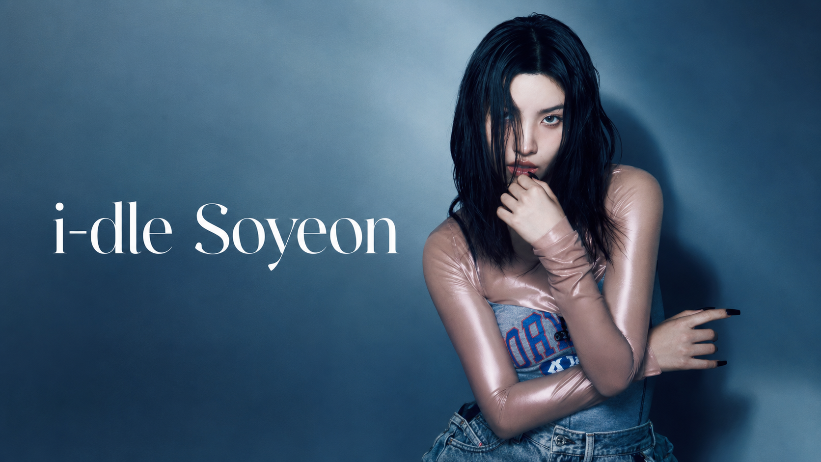 i-dle Soyeon 宣傳肖像,長黑髮女性穿粉色半透明長袖與牛仔服裝靠在藍灰背景前,畫面標示 i-dle Soyeon
