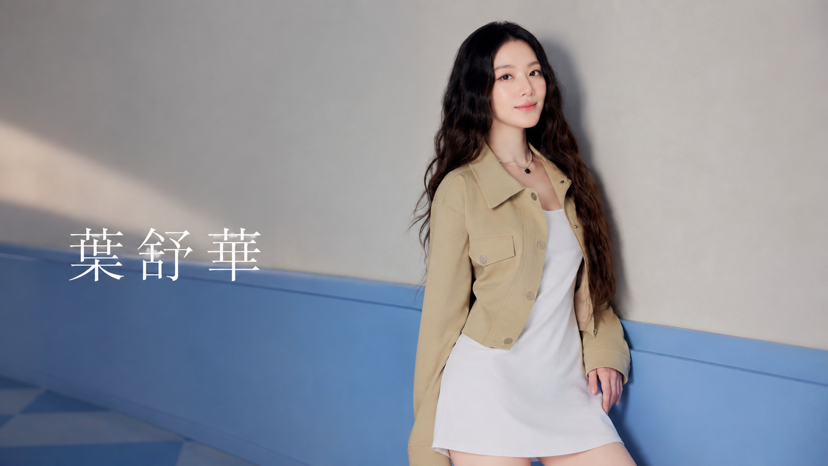 葉舒華穿米色外套與白色洋裝站在藍灰牆前,畫面標示葉舒華